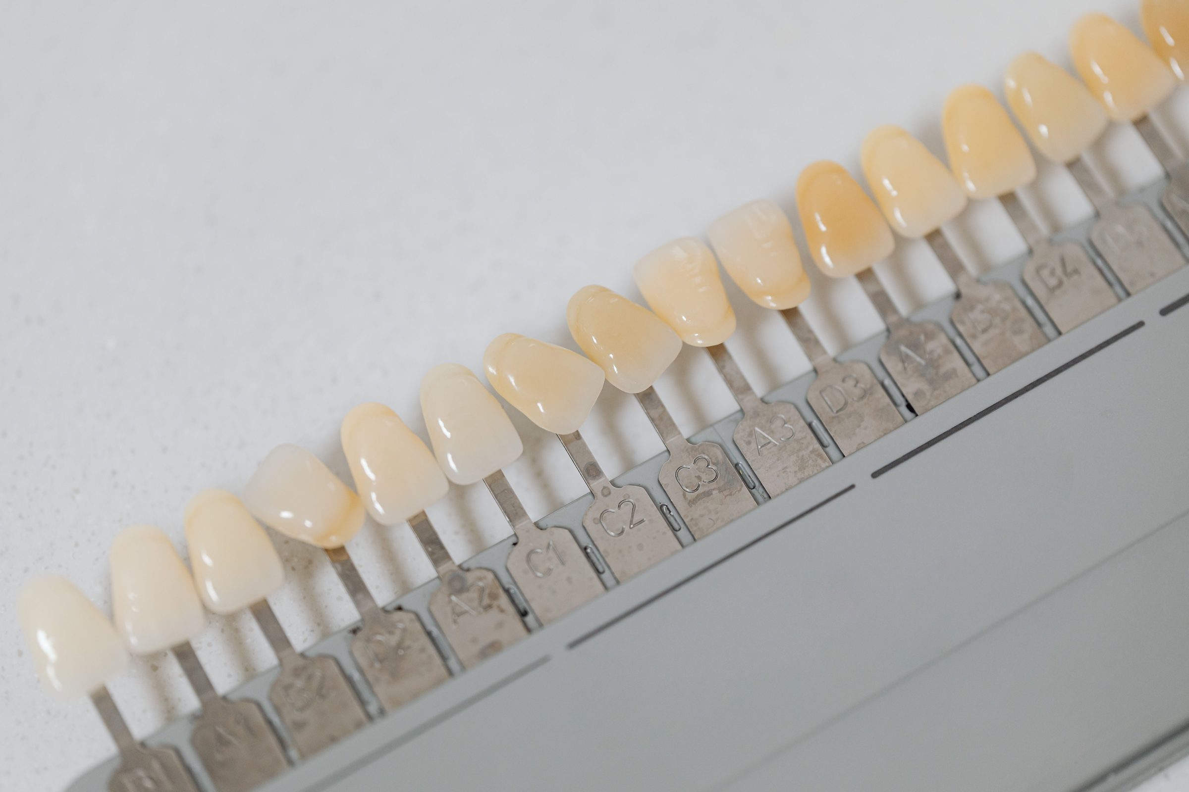 Escala de cor odontológica com amostras de tonalidade dos dentes, em close.
